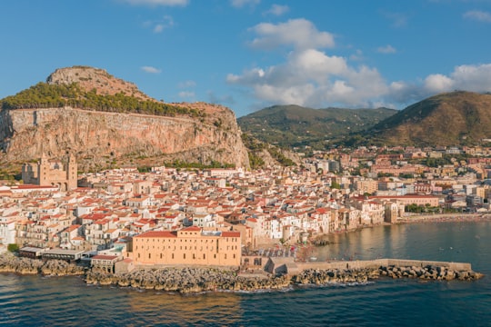 white and brown concrete buildings near body of water during daytime in Cefalù Italy