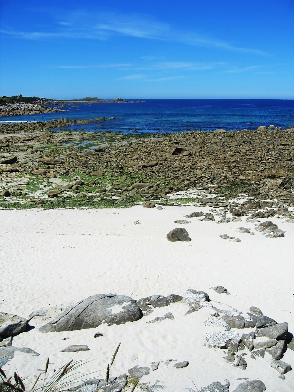 roches grises sur la plage de sable blanc pendant la journée