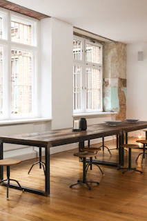 Dark industrial style wooden table with metal legs in a moody room
