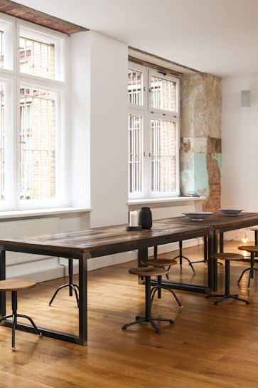 Dark industrial style wooden table with metal legs in a moody room