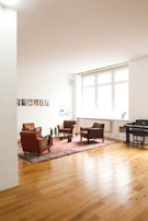 Interior view of a spacious living room with minimalist furniture and warm lighting.