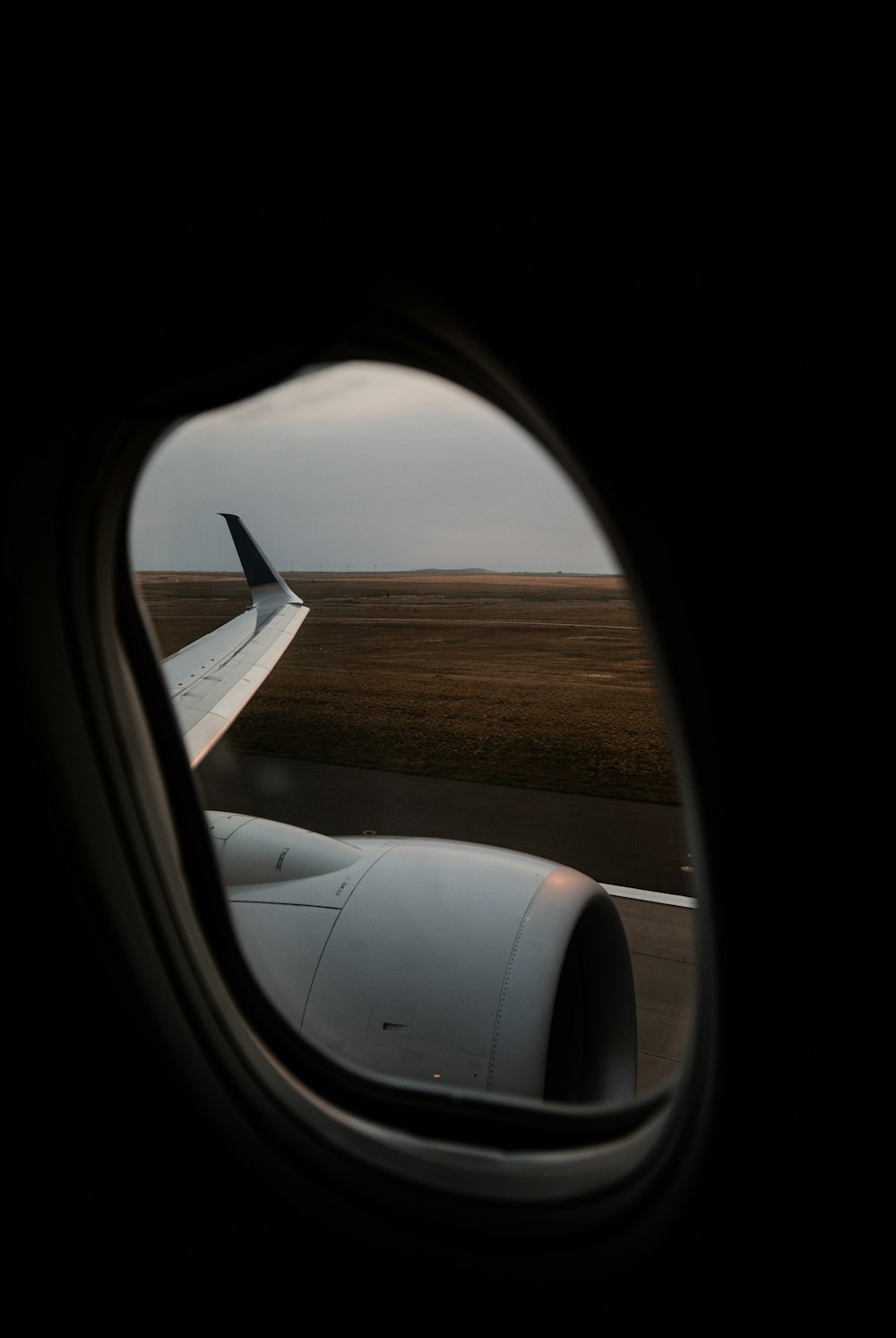ala bianca dell'aeroplano sopra il campo marrone durante il giorno