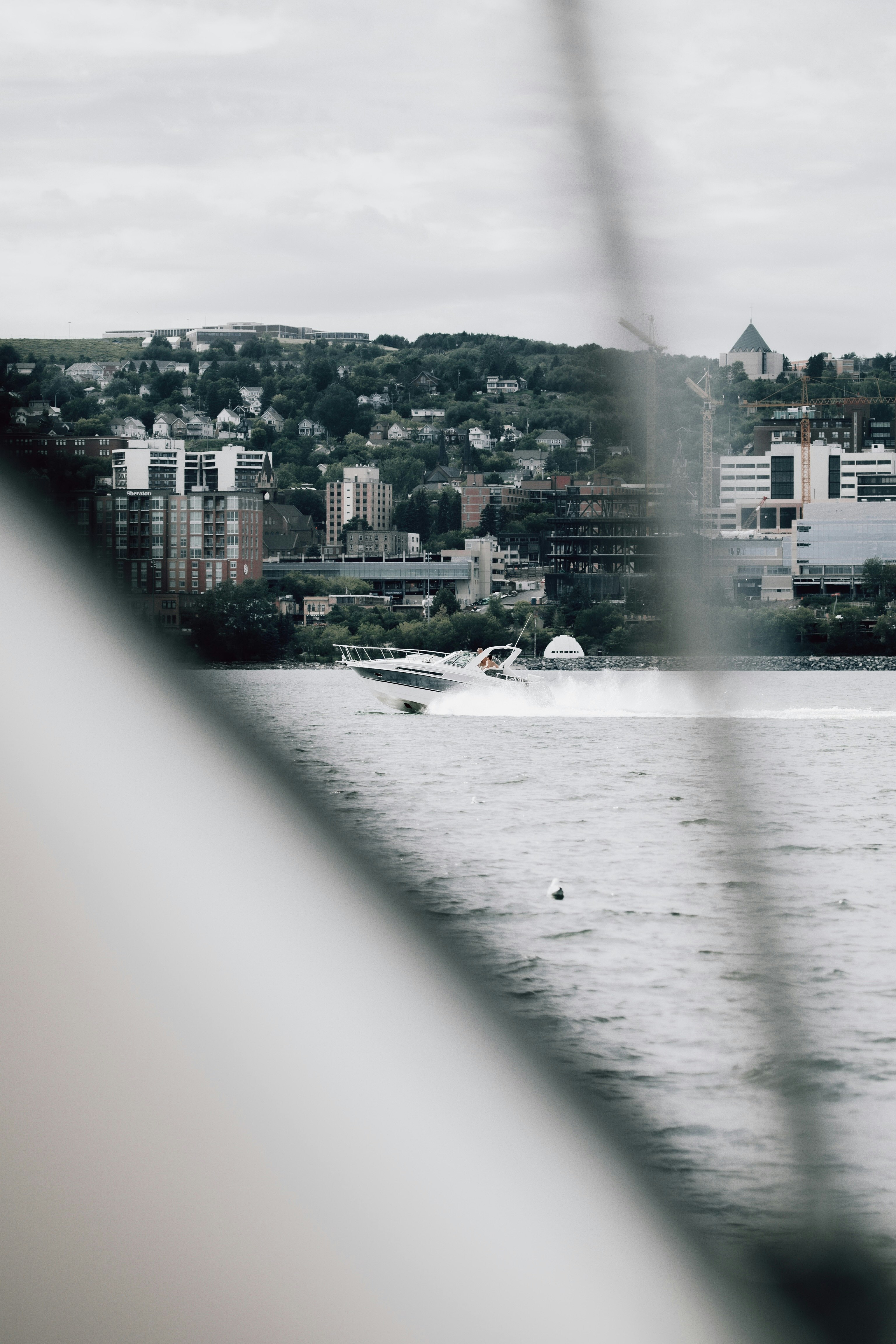 white boat on water near city buildings during daytime