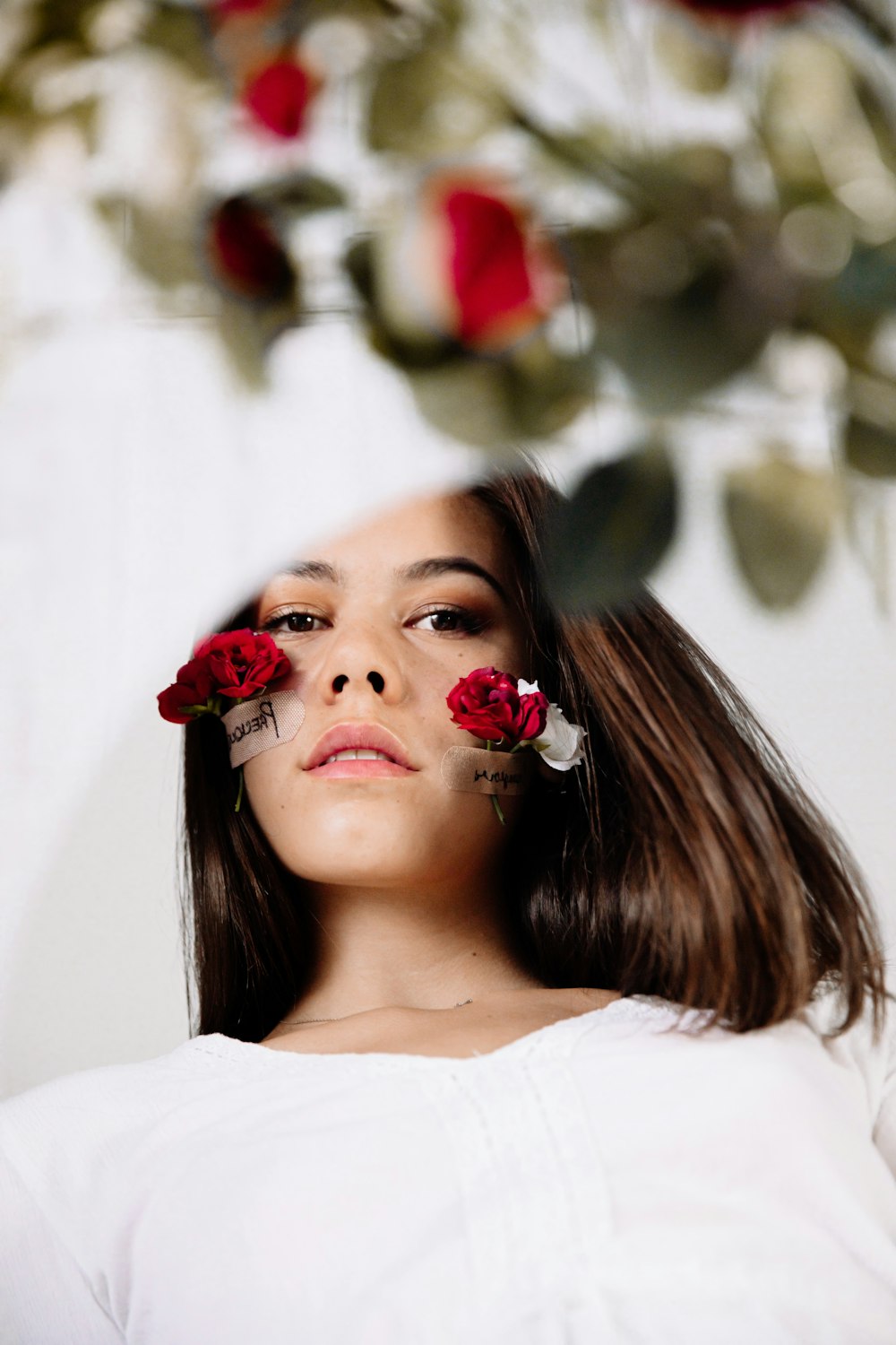 woman in white shirt with red flower on ear