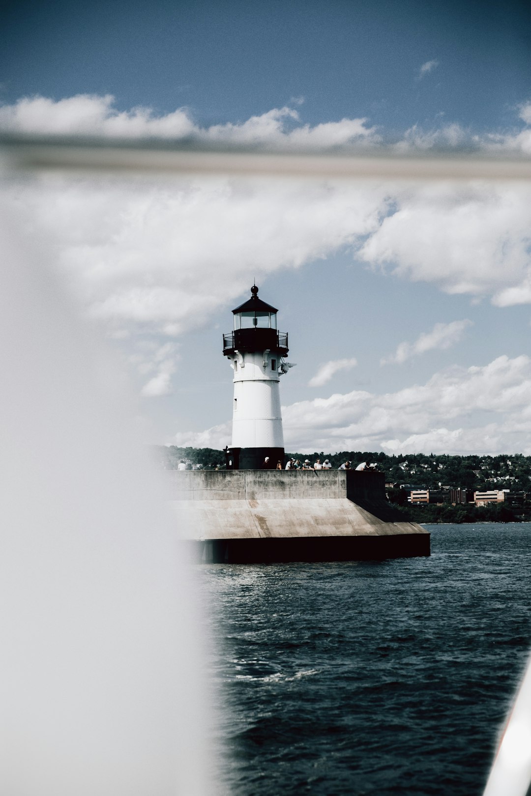 white and red lighthouse near body of water during daytime