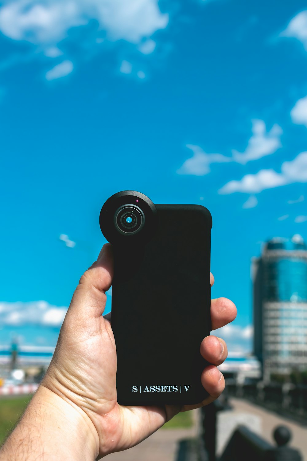 person holding black smartphone taking photo of city buildings during daytime
