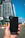 Close-up image of a young woman happily holding sleek gadget accessories in a modern urban setting.