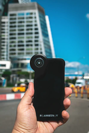Lifestyle shot of a person holding a futuristic black and blue smart accessory while walking in the city at night.