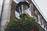Close-up of a modern street lamp surrounded by neatly manicured gardens.