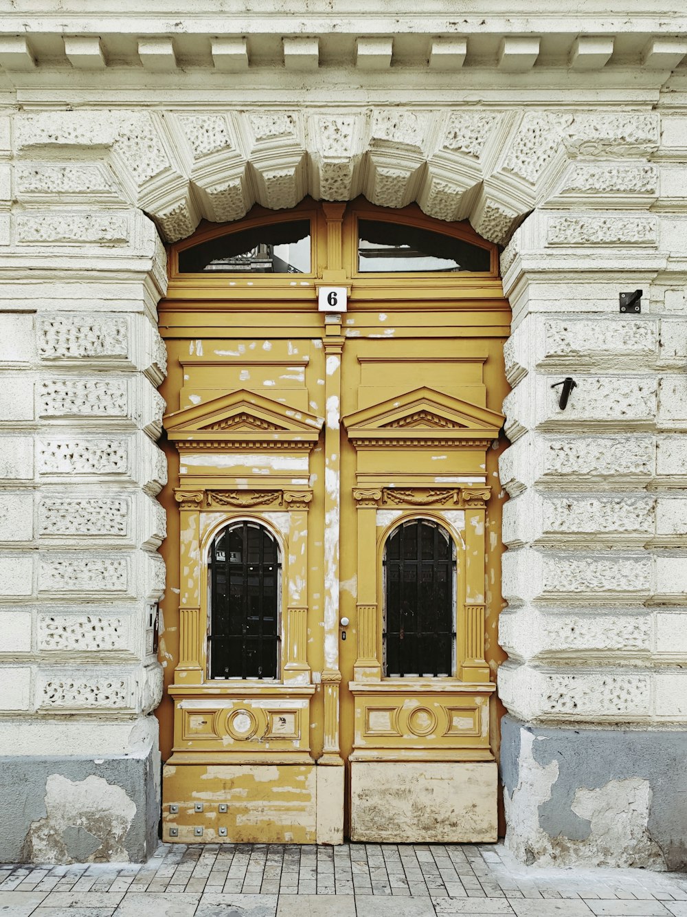 brown wooden door on white concrete wall