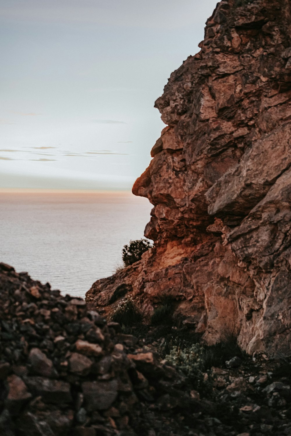 brown rock formation near body of water during daytime