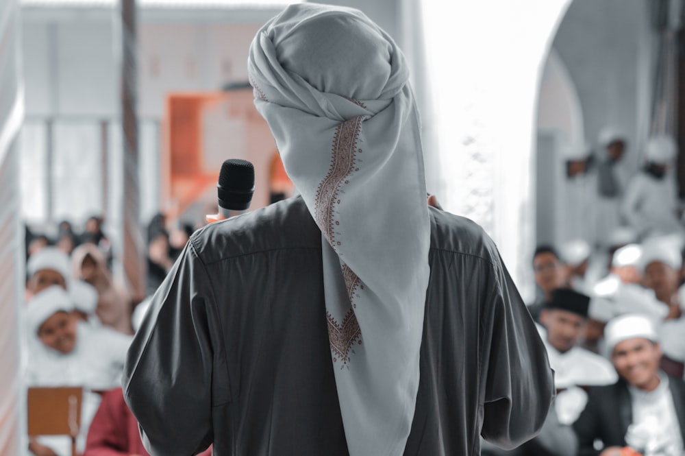 persona in hijab bianco e camicia nera a maniche lunghe