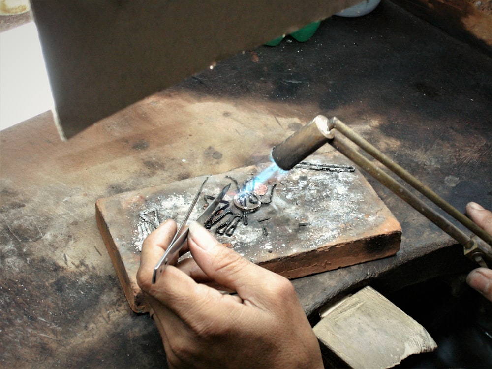 person holding gray metal tool