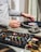 person in gray long sleeve shirt holding black and white dj controller