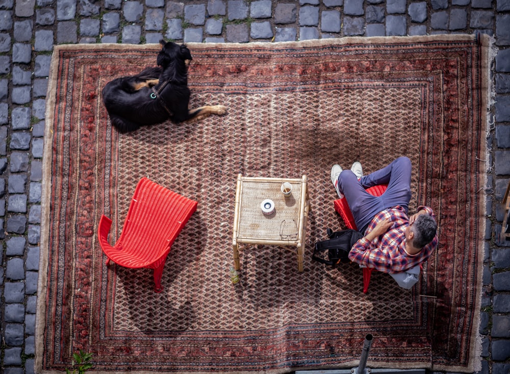 man in white long sleeve shirt lying on red and white rug