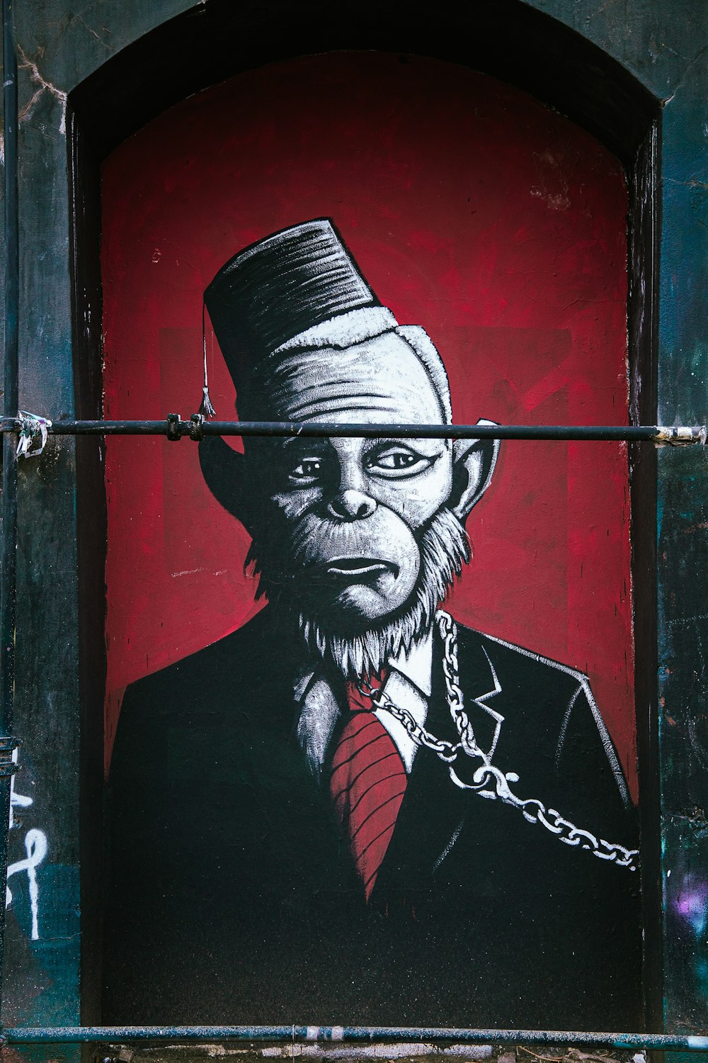 Mann mit schwarzer Strickmütze und rot-schwarzer Anzugjacke Graffiti