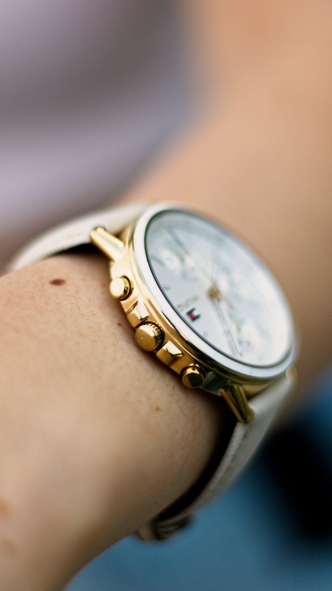 person wearing gold and white analog watch