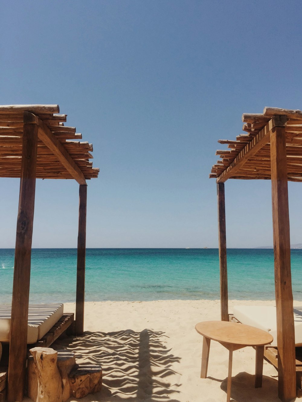 brown wooden beach dock on white sand beach during daytime