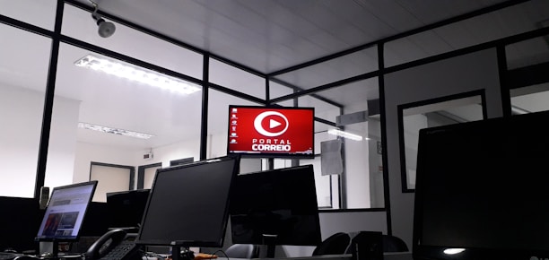 An office space with computers and logistics management software displayed on screens.