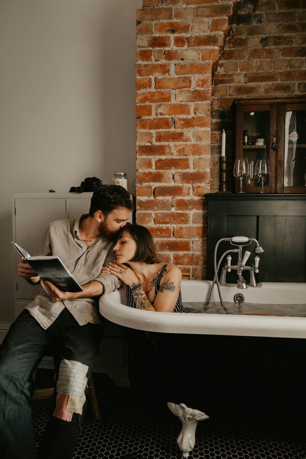 man and woman kissing on bathtub