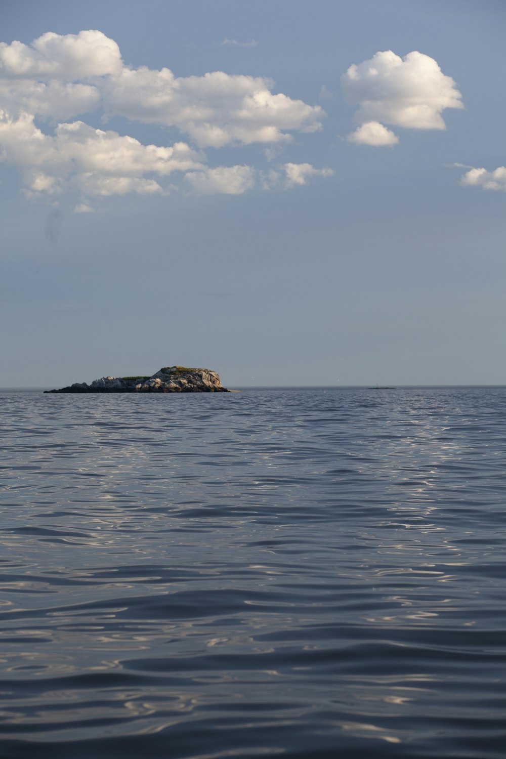 brown rock formation on blue sea under blue sky during daytime