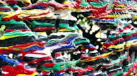 An abstract sculpture featuring thick, intertwined layers of brightly colored paint in red, green, yellow, white, blue, and black, creating a visually chaotic and textured pattern.