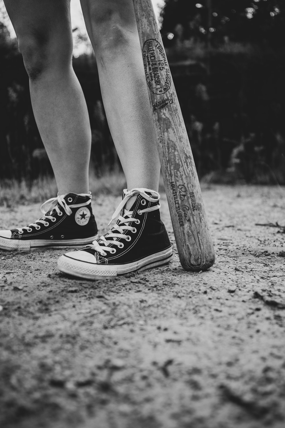 grayscale photo of person wearing converse all star high top sneakers