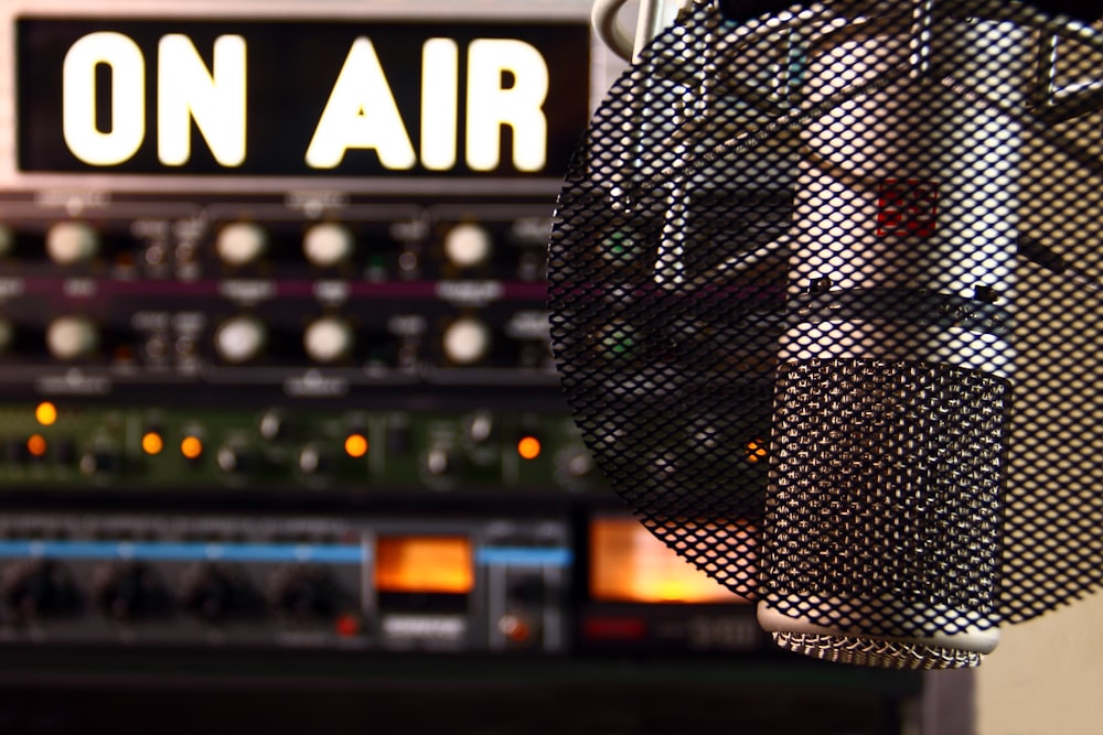 a close-up picture of a radio broadcast microphone overlooking a studio backdrop.