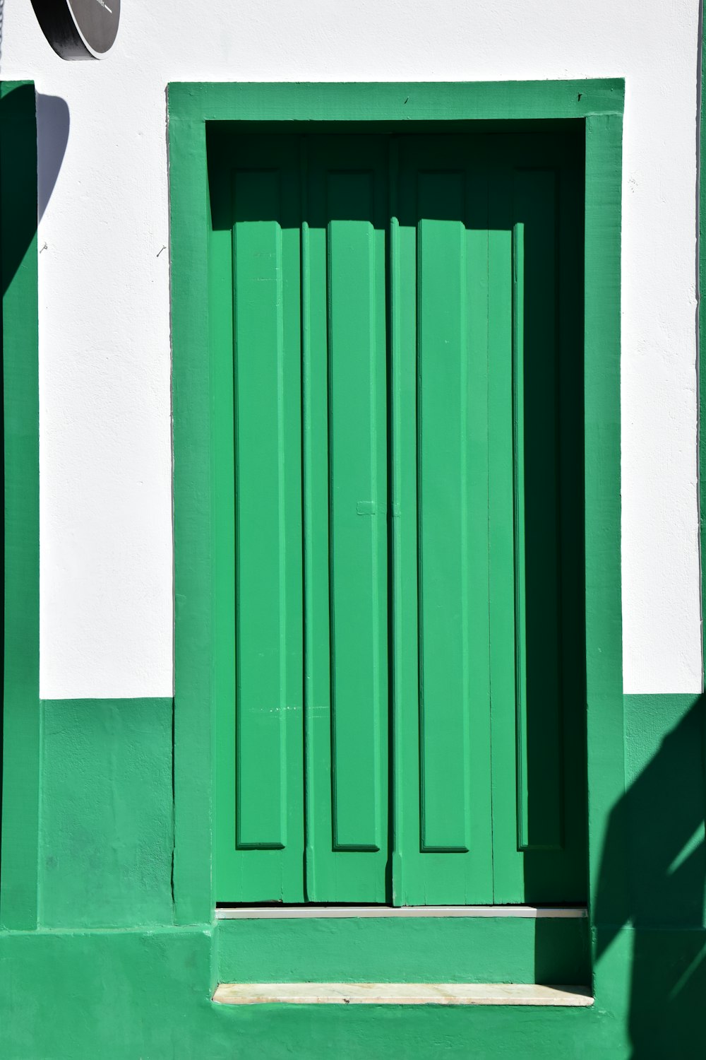 green wooden door on white painted wall