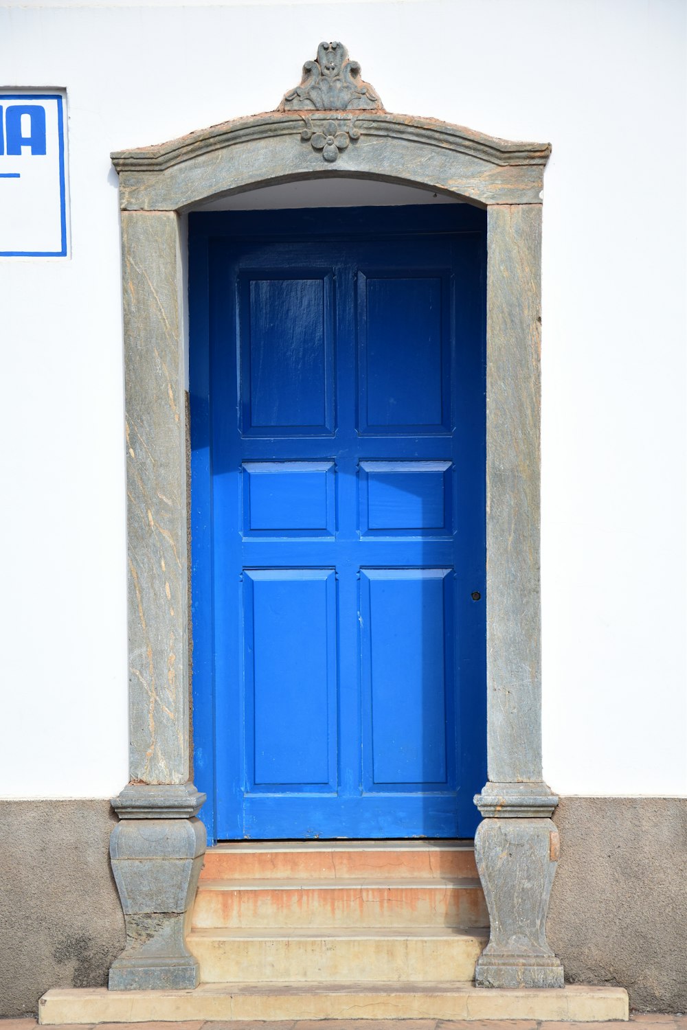 puerta de madera azul sobre pared de hormigón gris