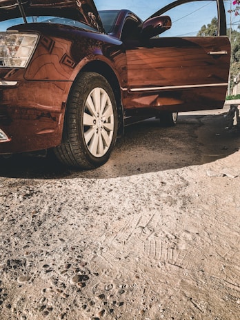 A professional appraiser inspecting a vehicle's exterior under natural light.