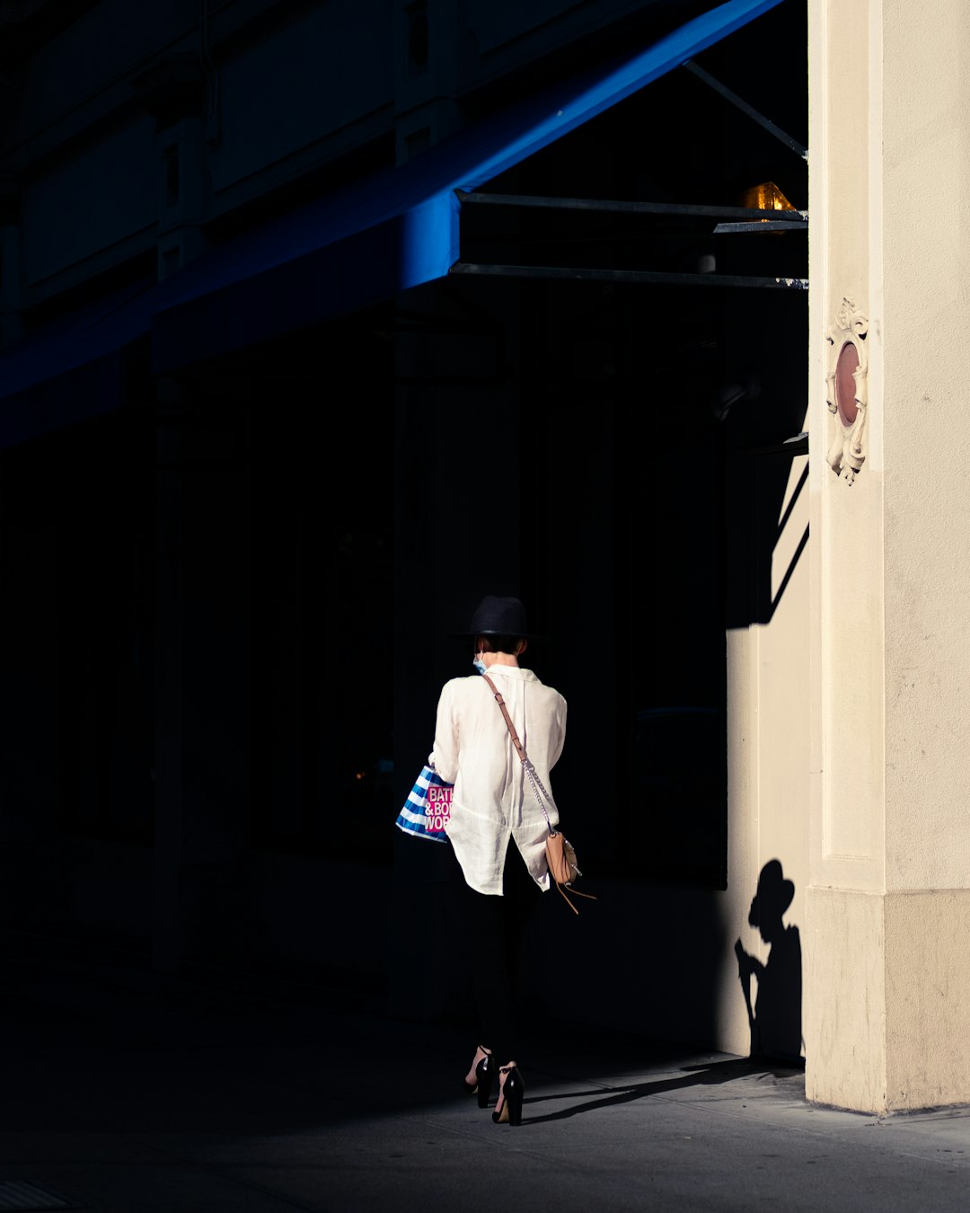 man in white suit standing beside white wall