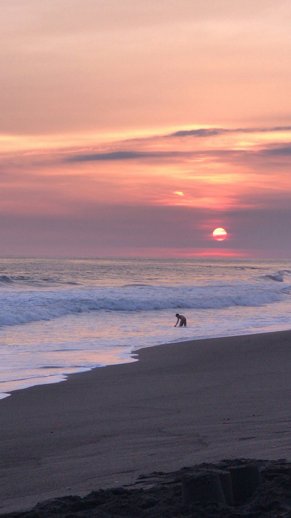 person walking on beach during sunset