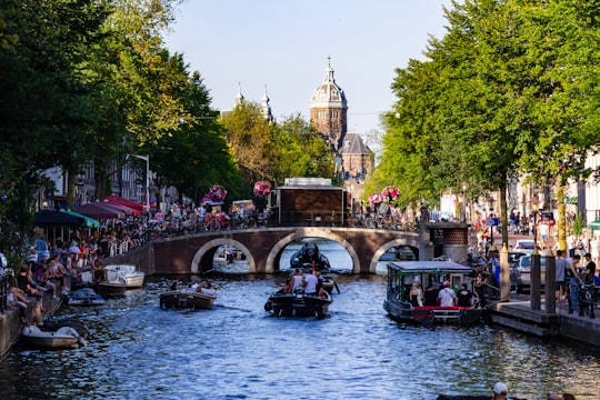 people riding on boat on river during daytime in Amsterdam Netherlands