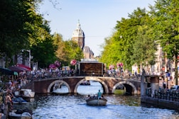 people riding on boat on river near bridge during daytime
