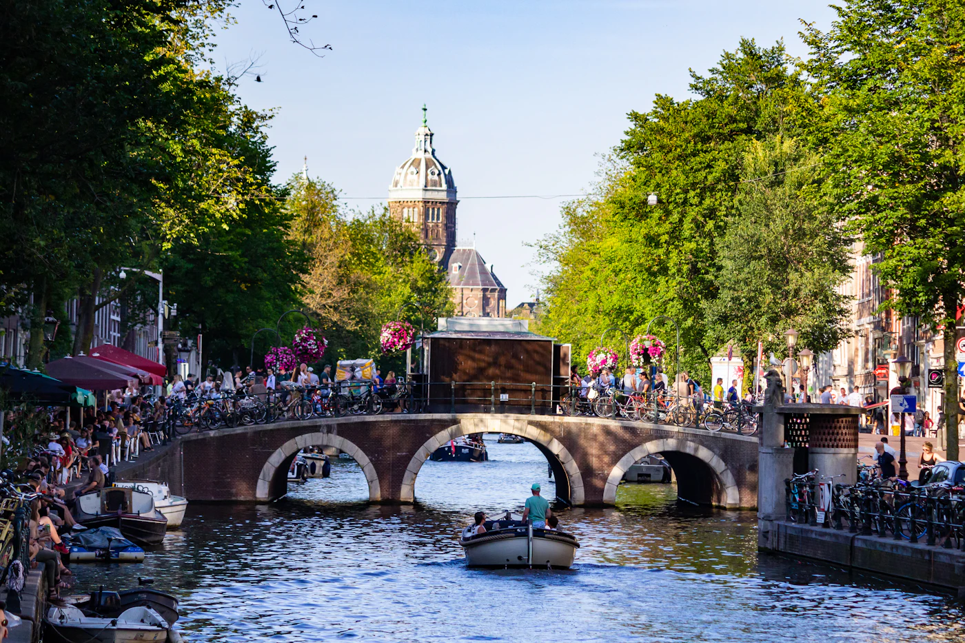 Mensen op een rondvaartboot bij een brug over de gracht