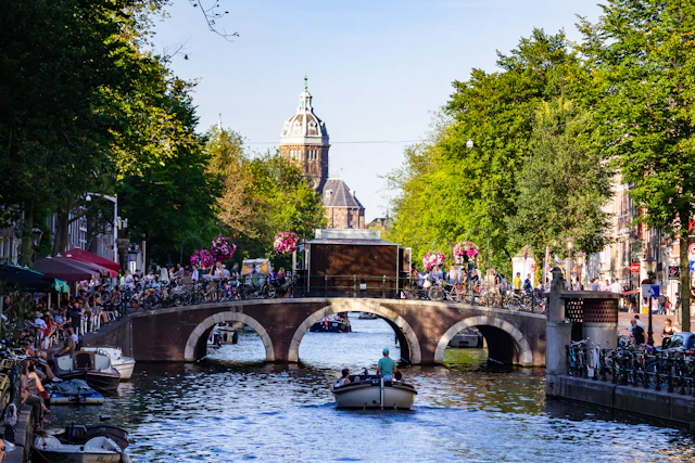 Mensen op een rondvaartboot bij een brug over de gracht