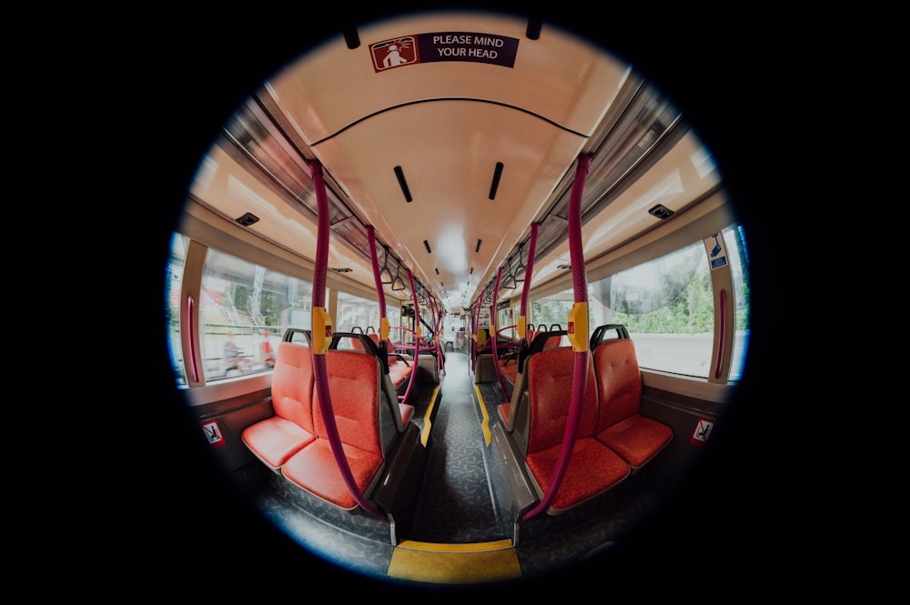 a view of the inside of a bus with red seats