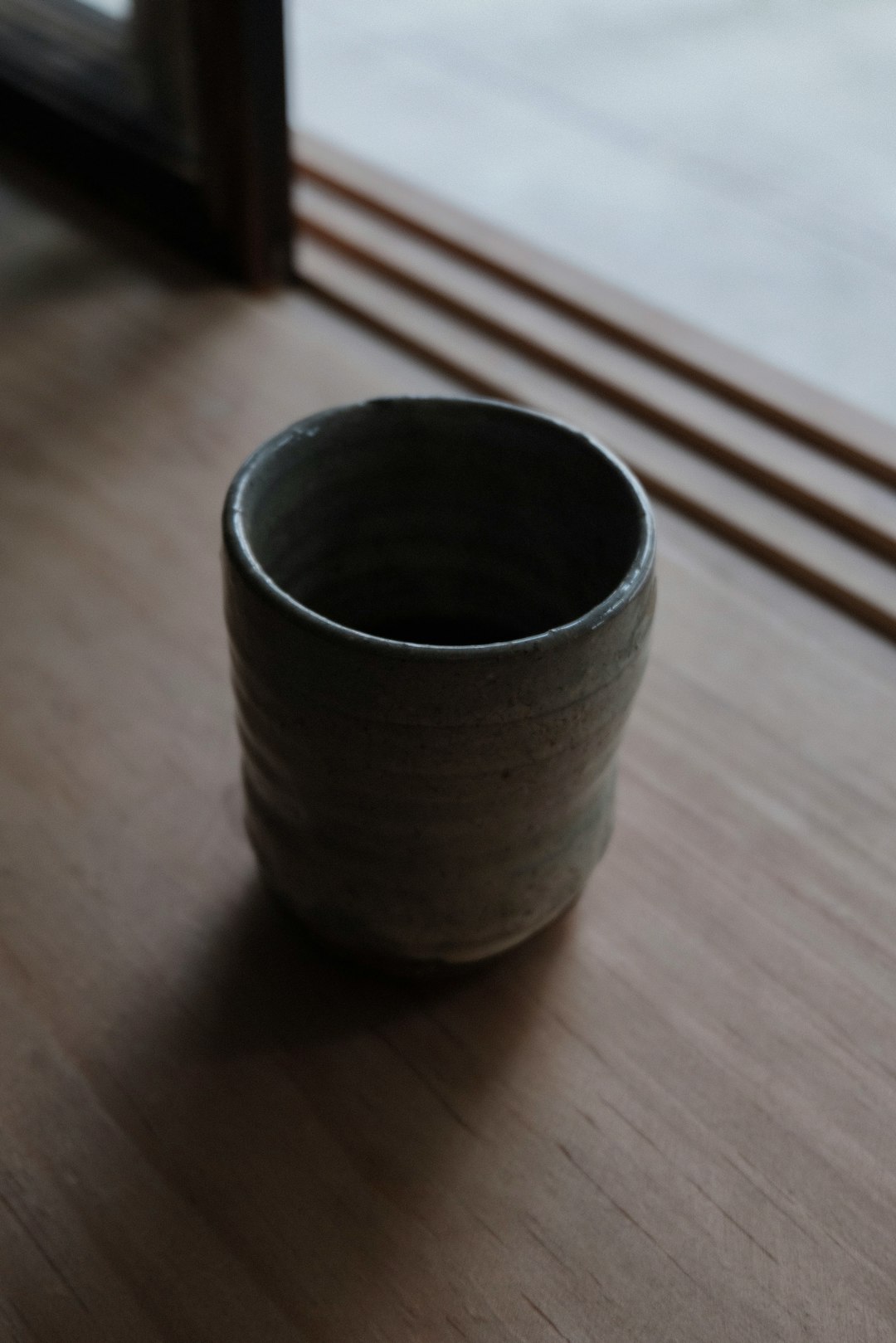 gray ceramic cup on brown wooden table