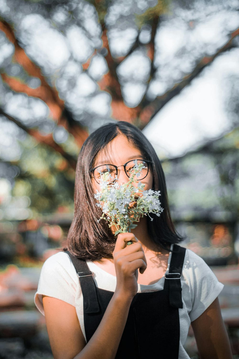 woman in white long sleeve shirt holding bouquet of flowers