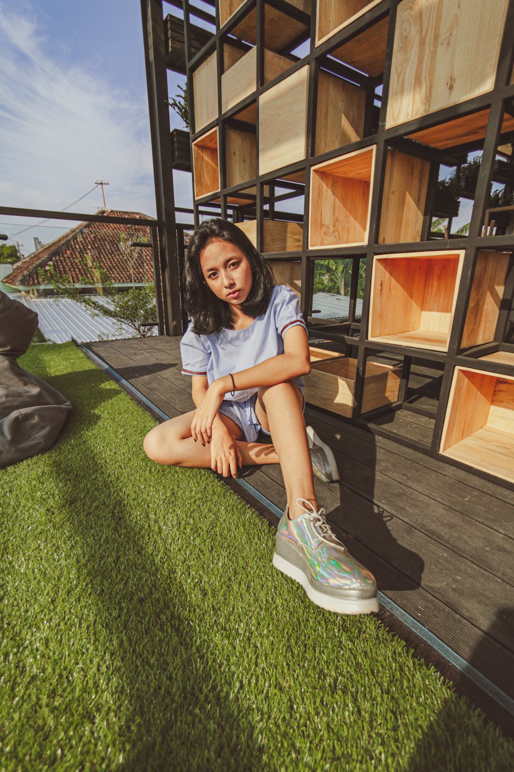 girl in white t-shirt and blue denim shorts sitting on green carpet