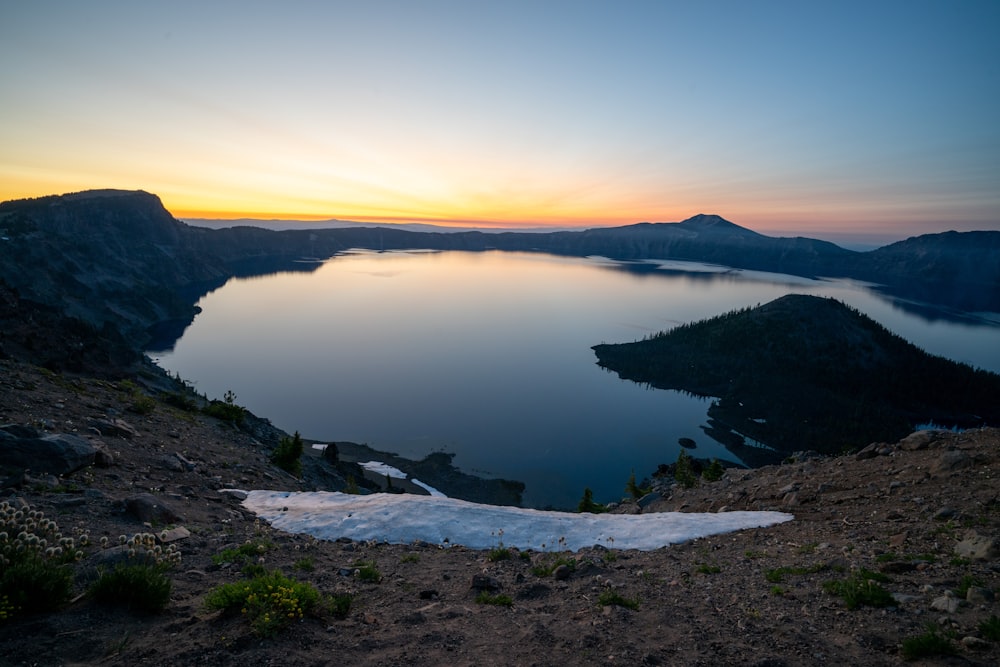 body of water near mountain during daytime