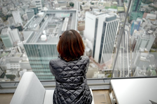 woman in black and white dress standing on white concrete building during daytime