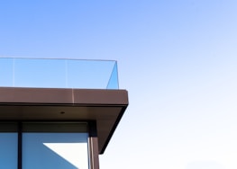 Elegant glass railing overlooking a pool area at sunset, highlighting the clean lines and clarity.