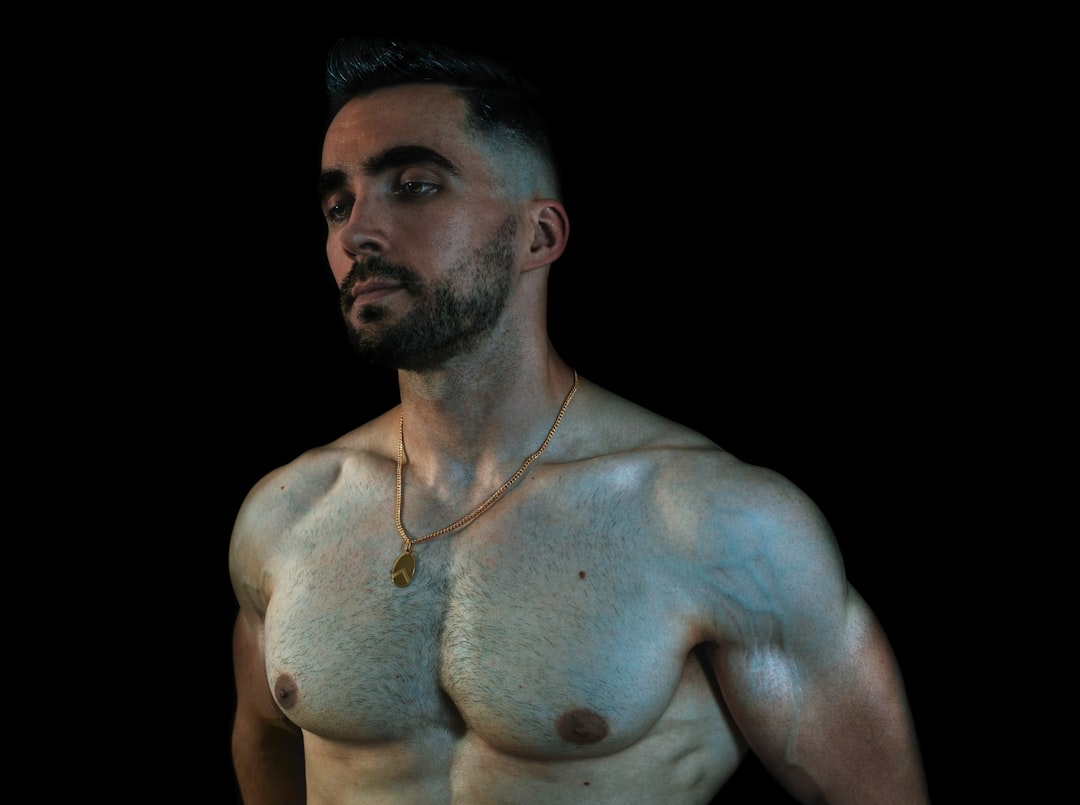 topless man wearing silver necklace,