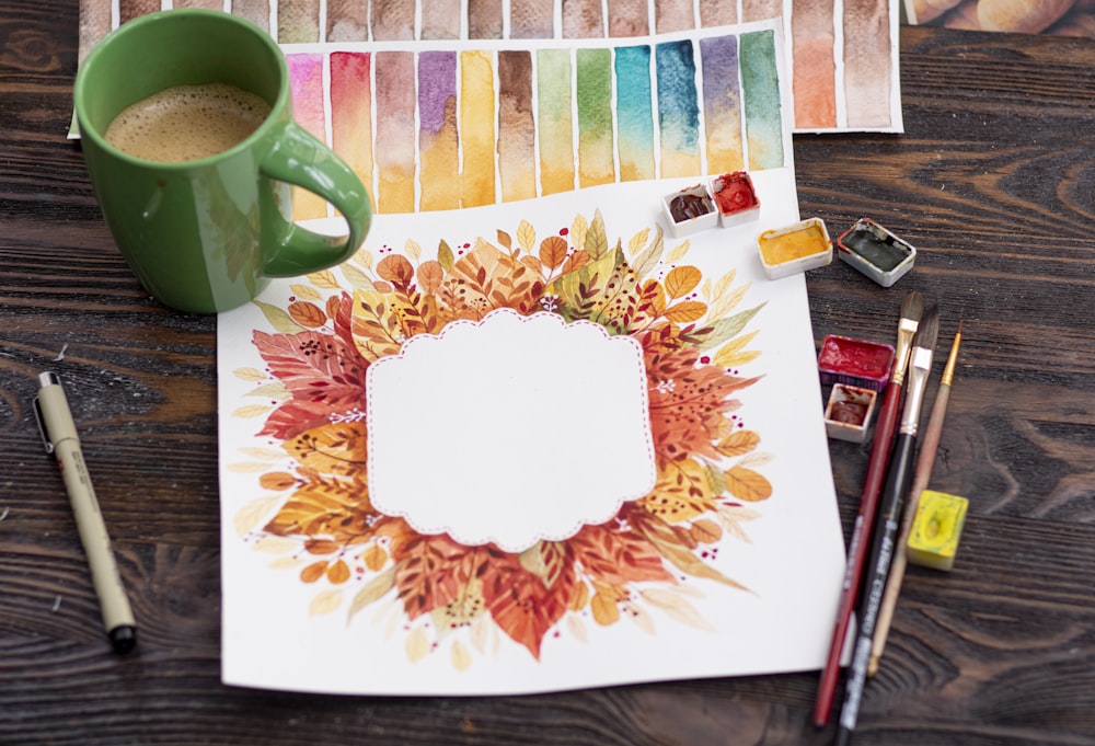 green ceramic mug on white and red floral table cloth