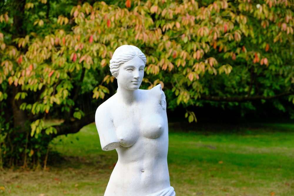 white concrete statue near green grass field during daytime