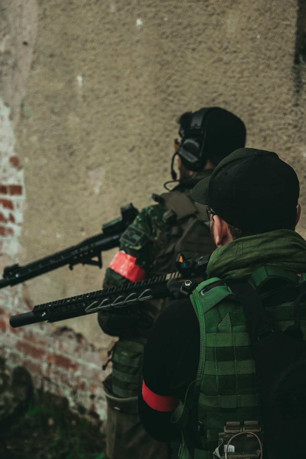 man in green and black camouflage jacket holding black rifle