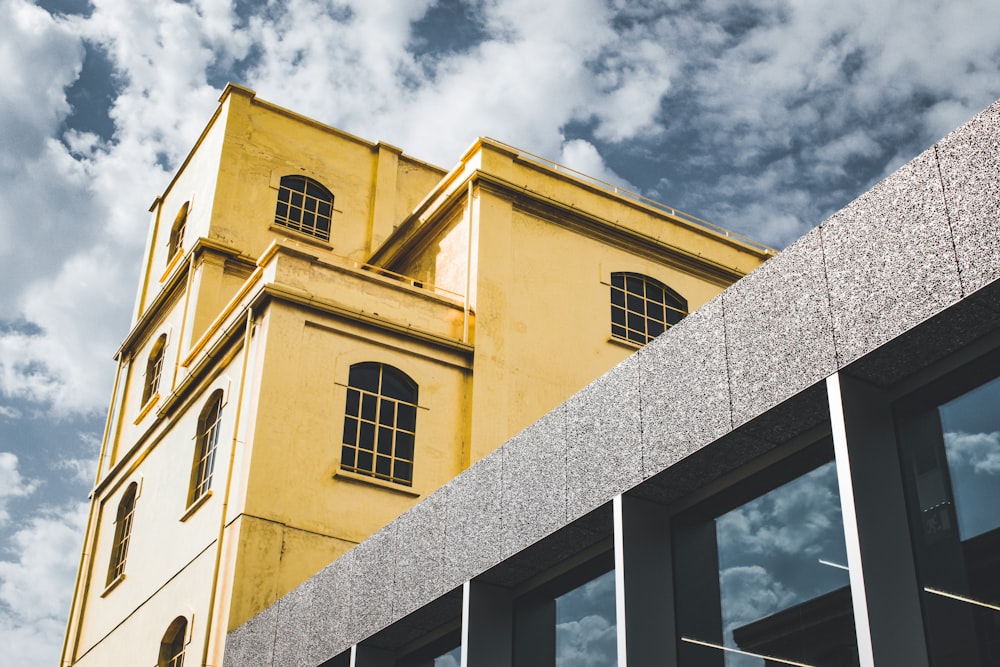 edifício de concreto amarelo sob céu nublado durante o dia