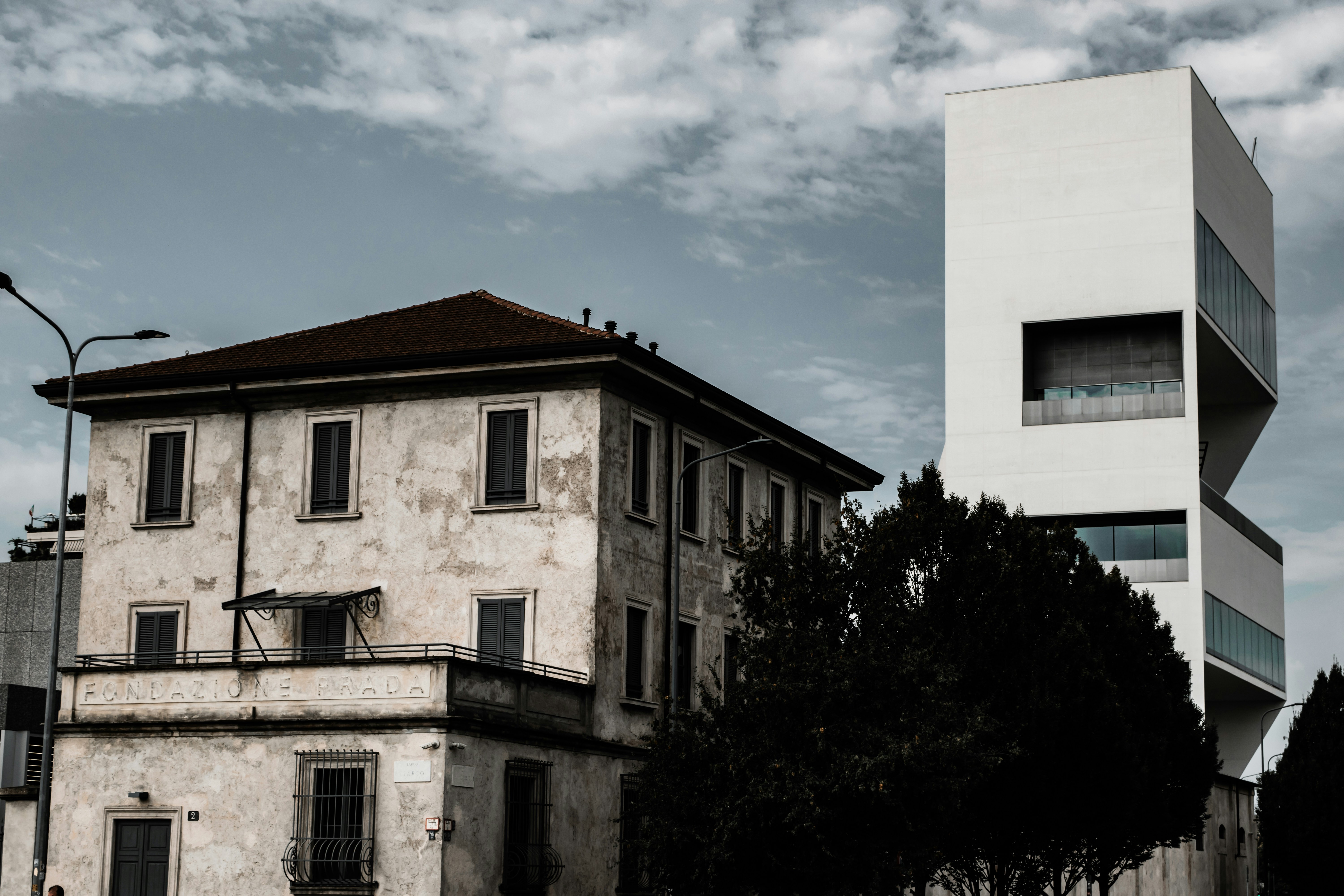 white concrete building near green trees under blue sky during daytime